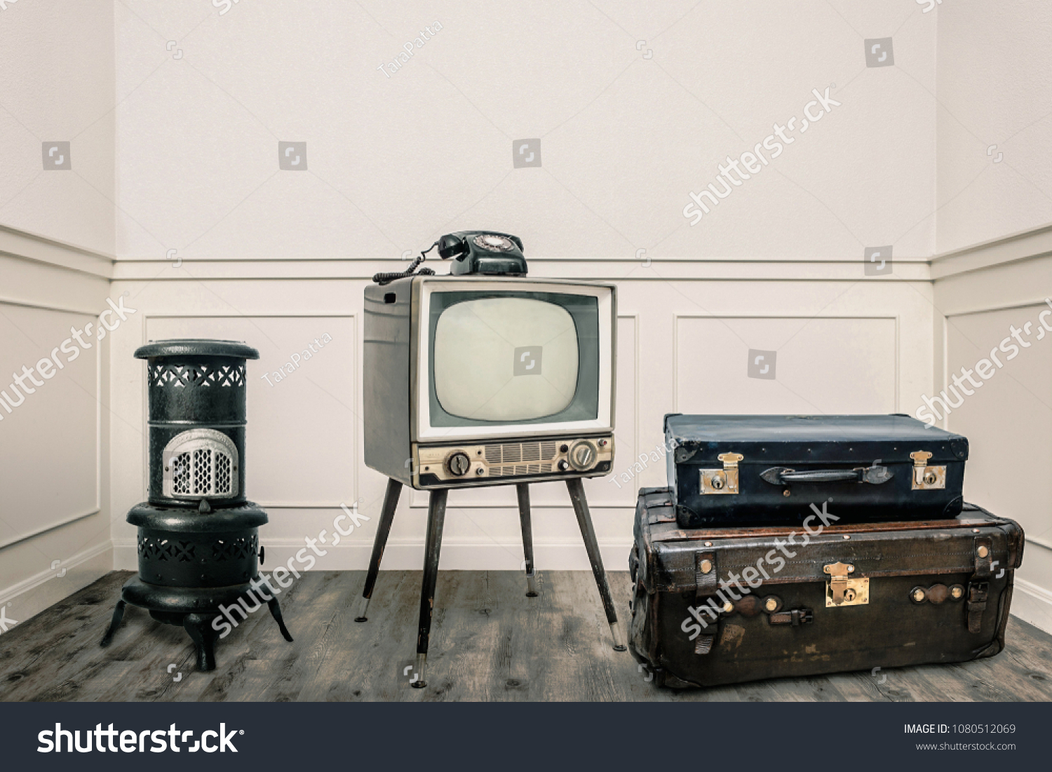 Vintage heater, television, and suitcases on floor in cozy room #1080512069