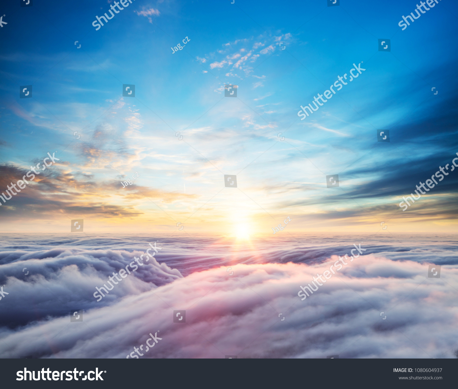 Beautiful sunset sky above clouds with dramatic light. Cabin view from airplane #1080604937