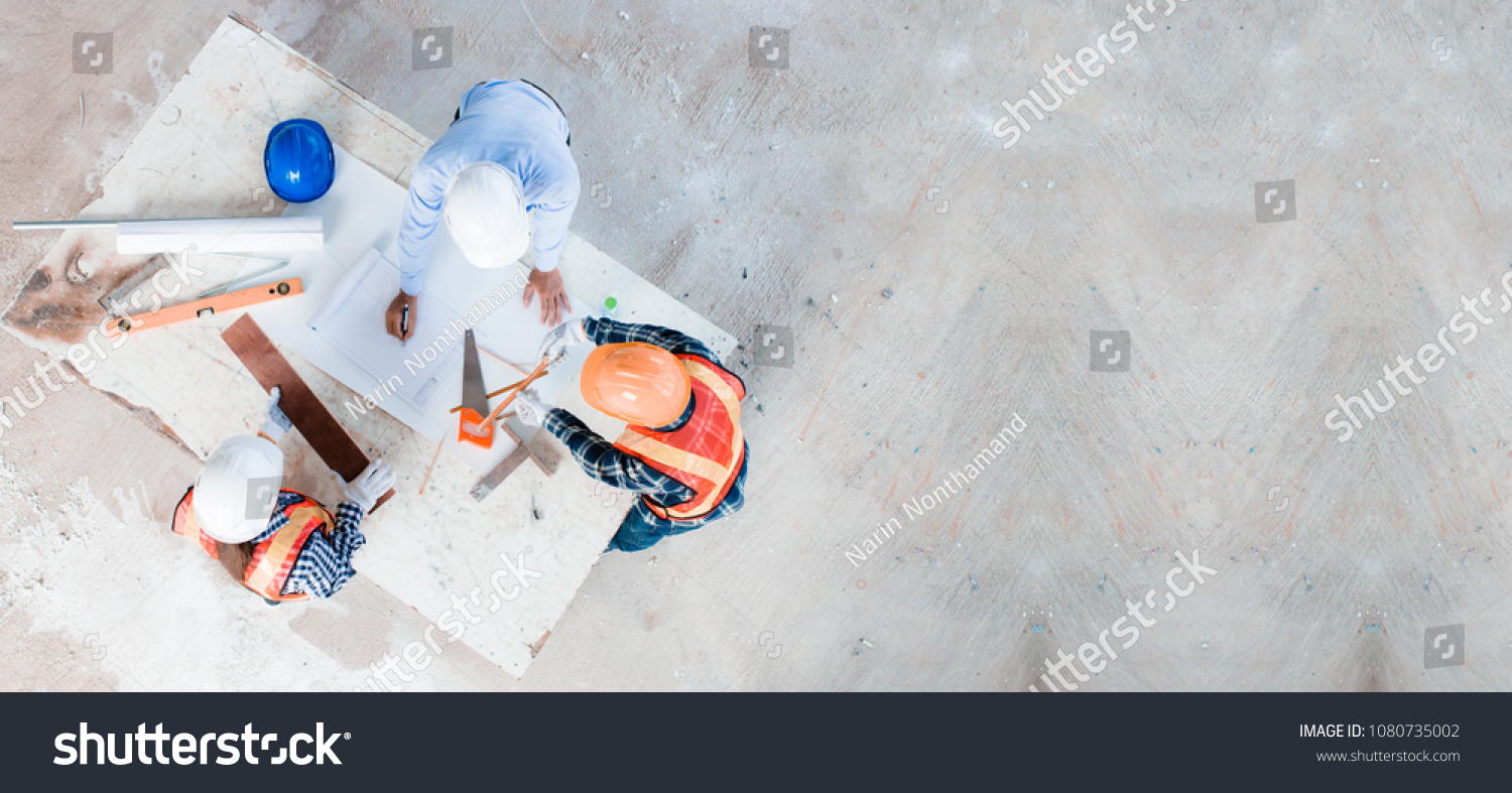 Team of young man and woman engineer and architects working, meeting, discussing,designing, planing, measuring layout of building blueprints in construction site floor at factory.top view & copy space #1080735002