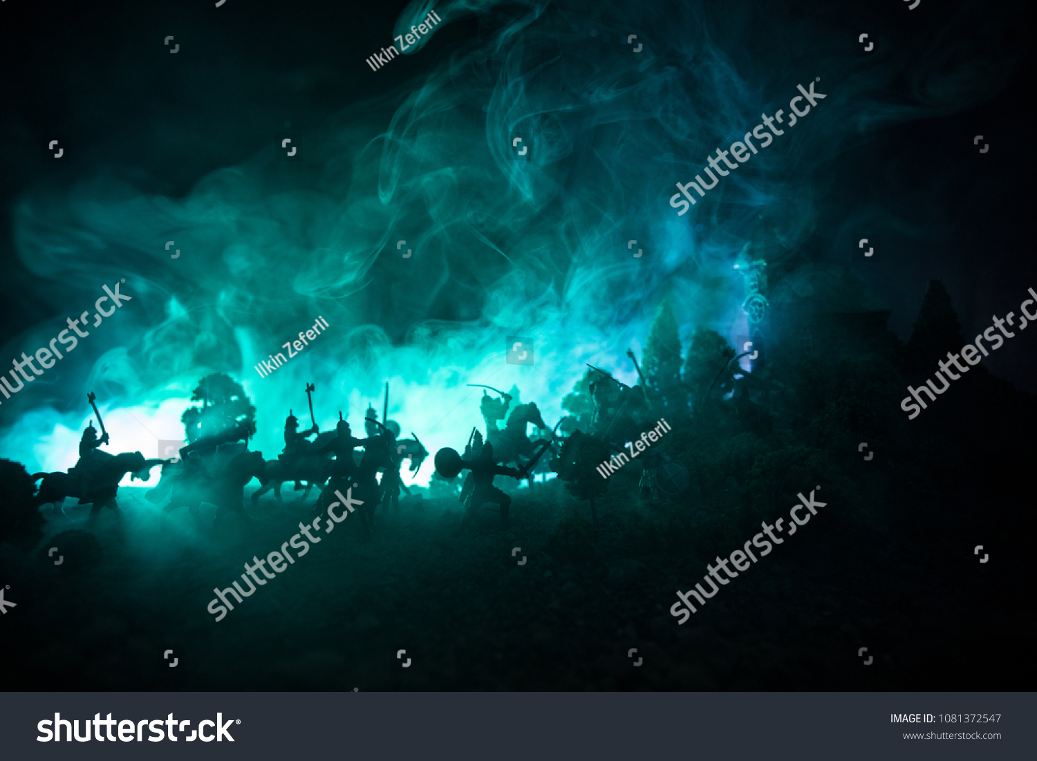 Medieval battle scene with cavalry and infantry. Silhouettes of figures as separate objects, fight between warriors on dark toned foggy background. Night scene. Selective focus #1081372547