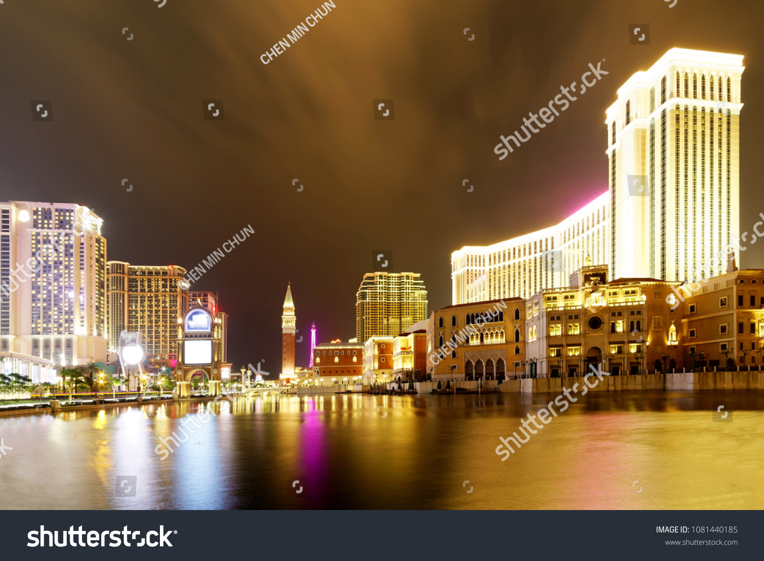 Night scenery of the grand exterior of The Venetian Macao among buildings of luxury hotels & extravagant casino resorts in Macau, China, with beautiful reflections of colorful neon lights in the water #1081440185