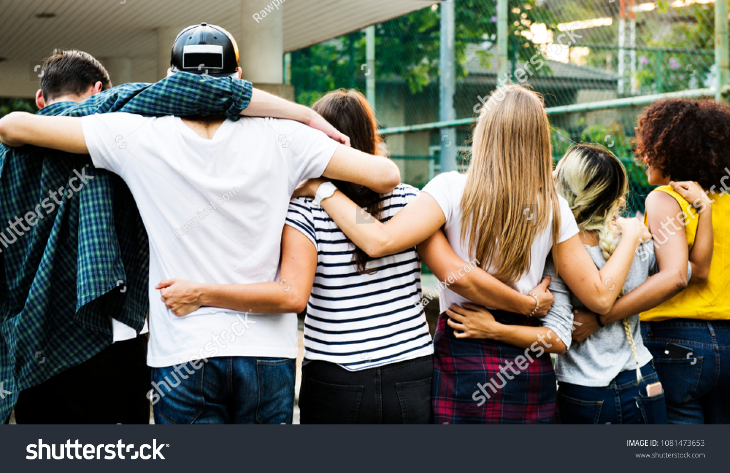 Smiling happy young adult friends arms around shoulder outdoors friendship and connection concept #1081473653