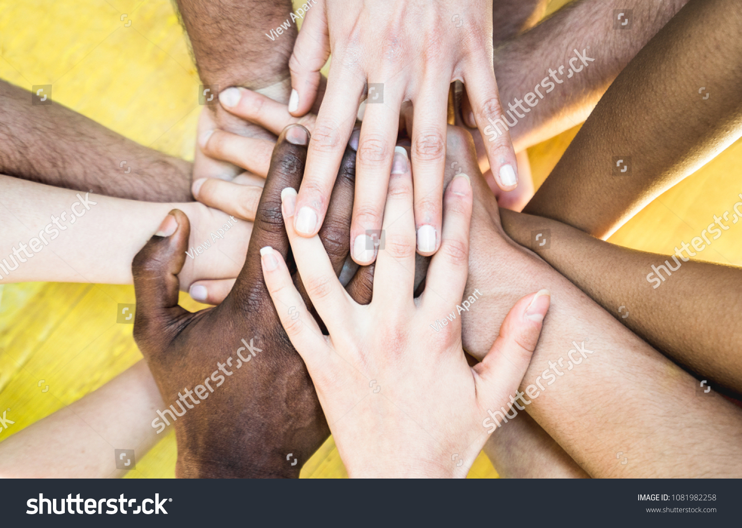 Top view of multicolored stacking hands - International friendship concept with multiethnic people representing peace and unity against racism - Multi racial love and integration between diversity #1081982258