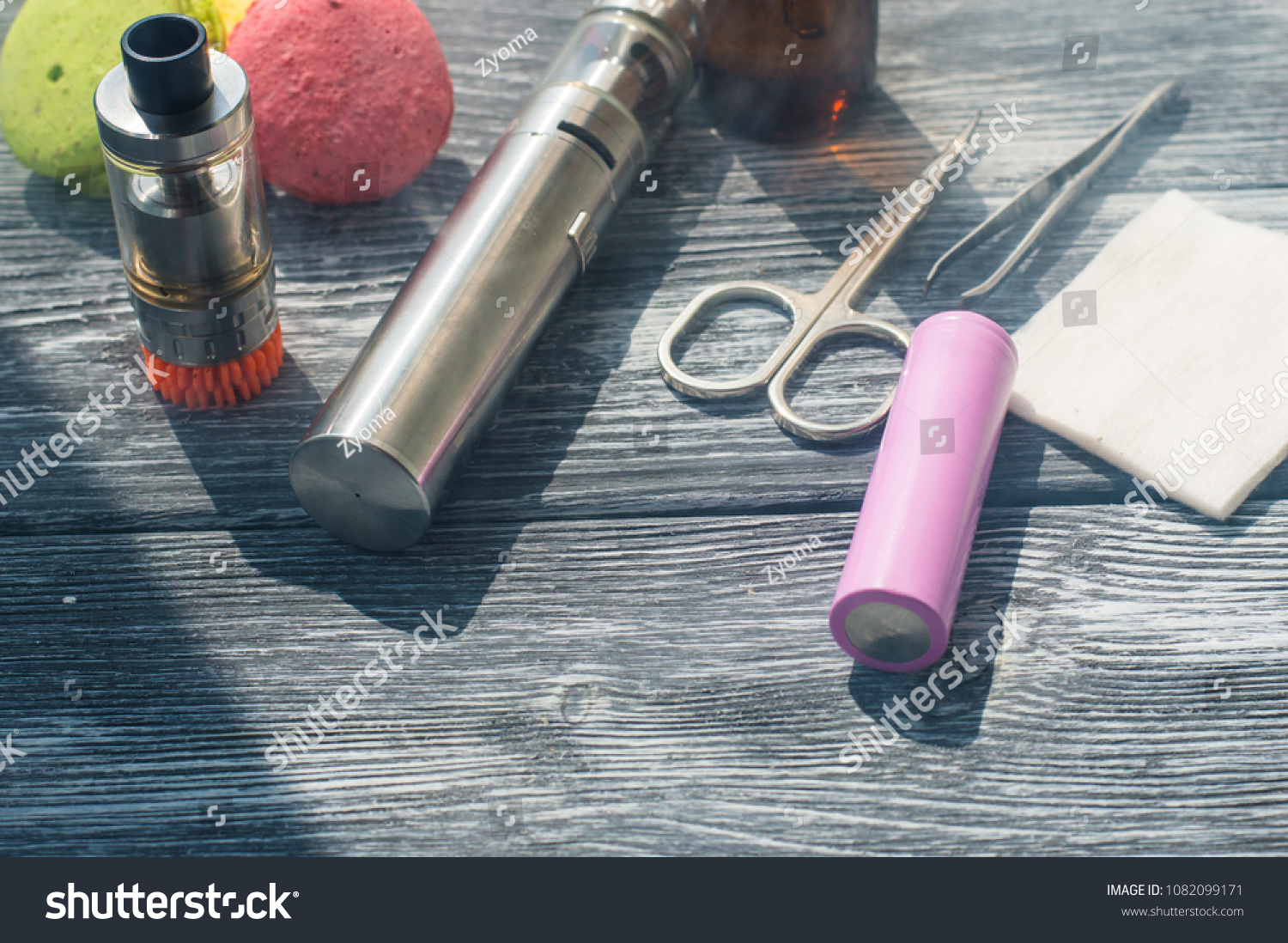 Still life with e-cig and jiuce on the wooden background #1082099171