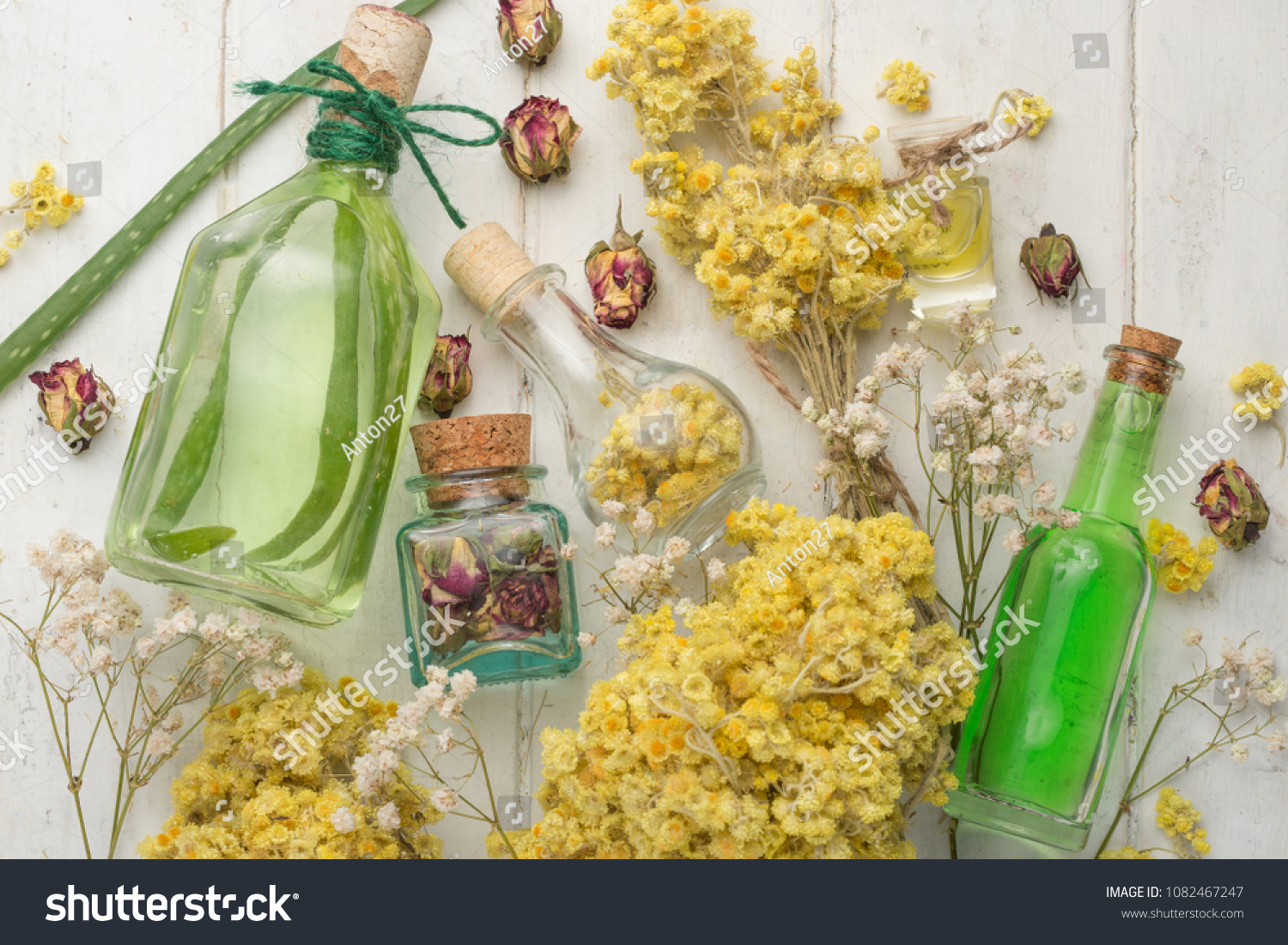 Aromatic oil, aromatic herbs in glass bottles, on a wooden background. The concept of body care and beauty #1082467247