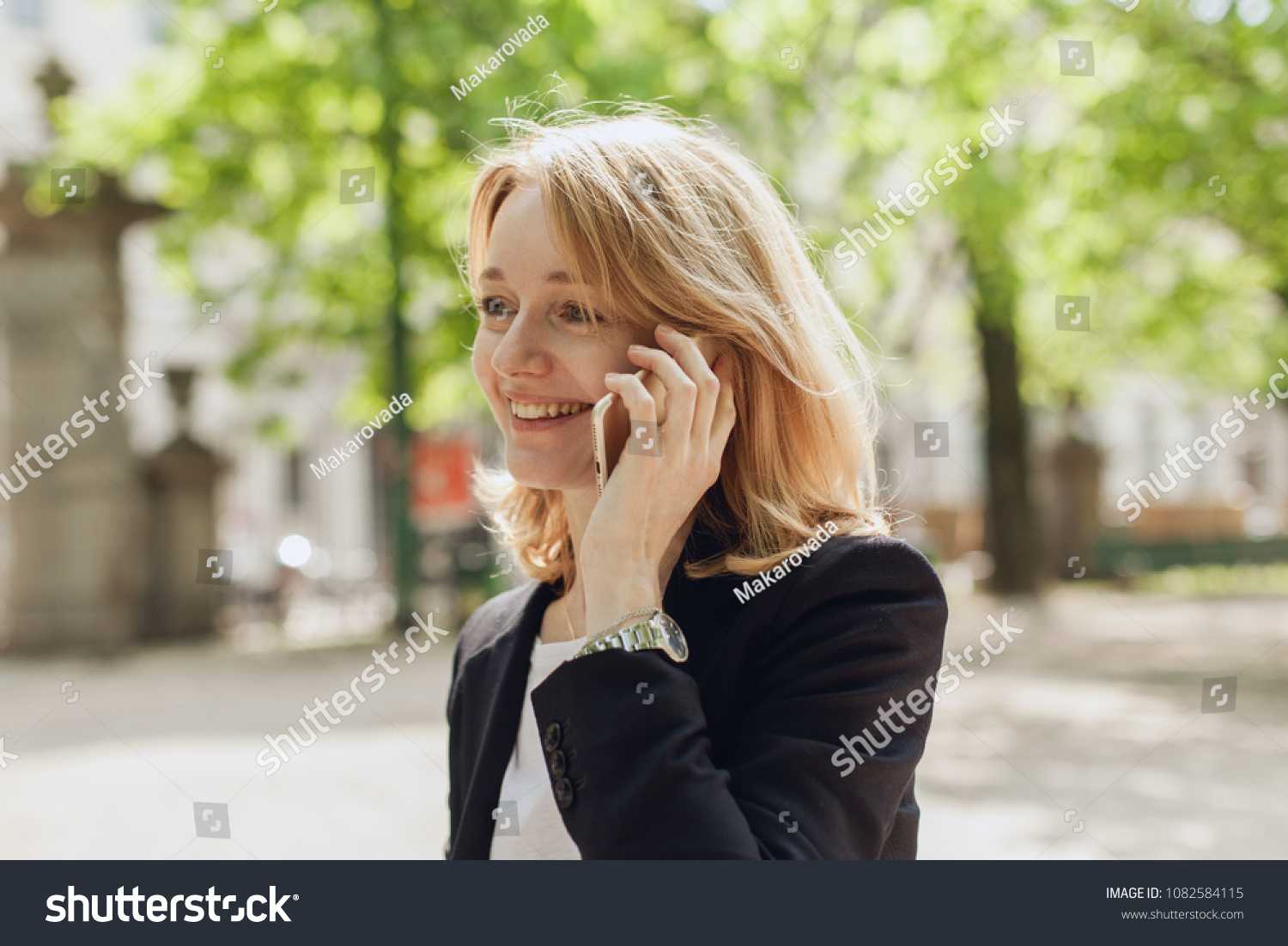 Portrait of smiling young businesswoman talking with cell phone, adult female manager using mobile phone for a call, happy successful manager having a conversation talk holding model gadget  #1082584115