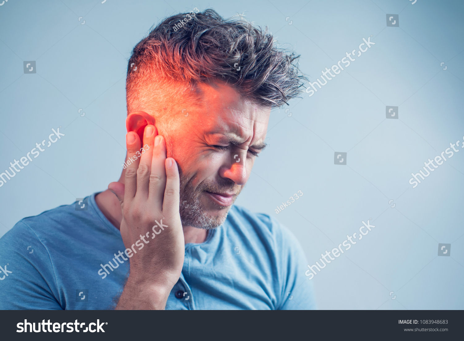 male having ear pain touching his painful head isolated on gray background #1083948683