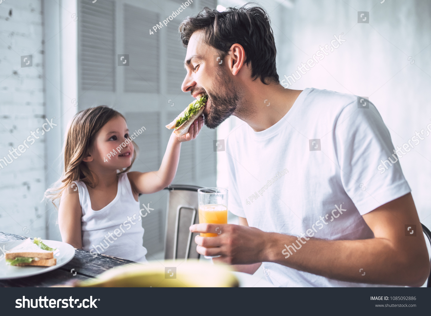 I love you, dad! Handsome young man at home with his little cute girl are having breakfast. Happy Father's Day!