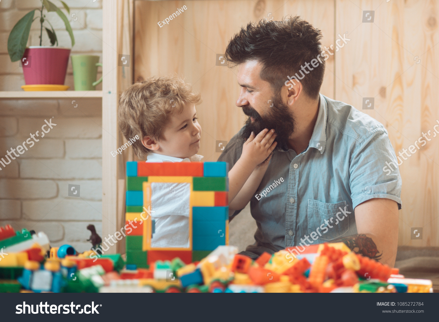 The boy touches his father's beard. An example and love. Tender feelings, family love. A good father. Father's Day. The son and father spend time together at home. A caring parent #1085272784