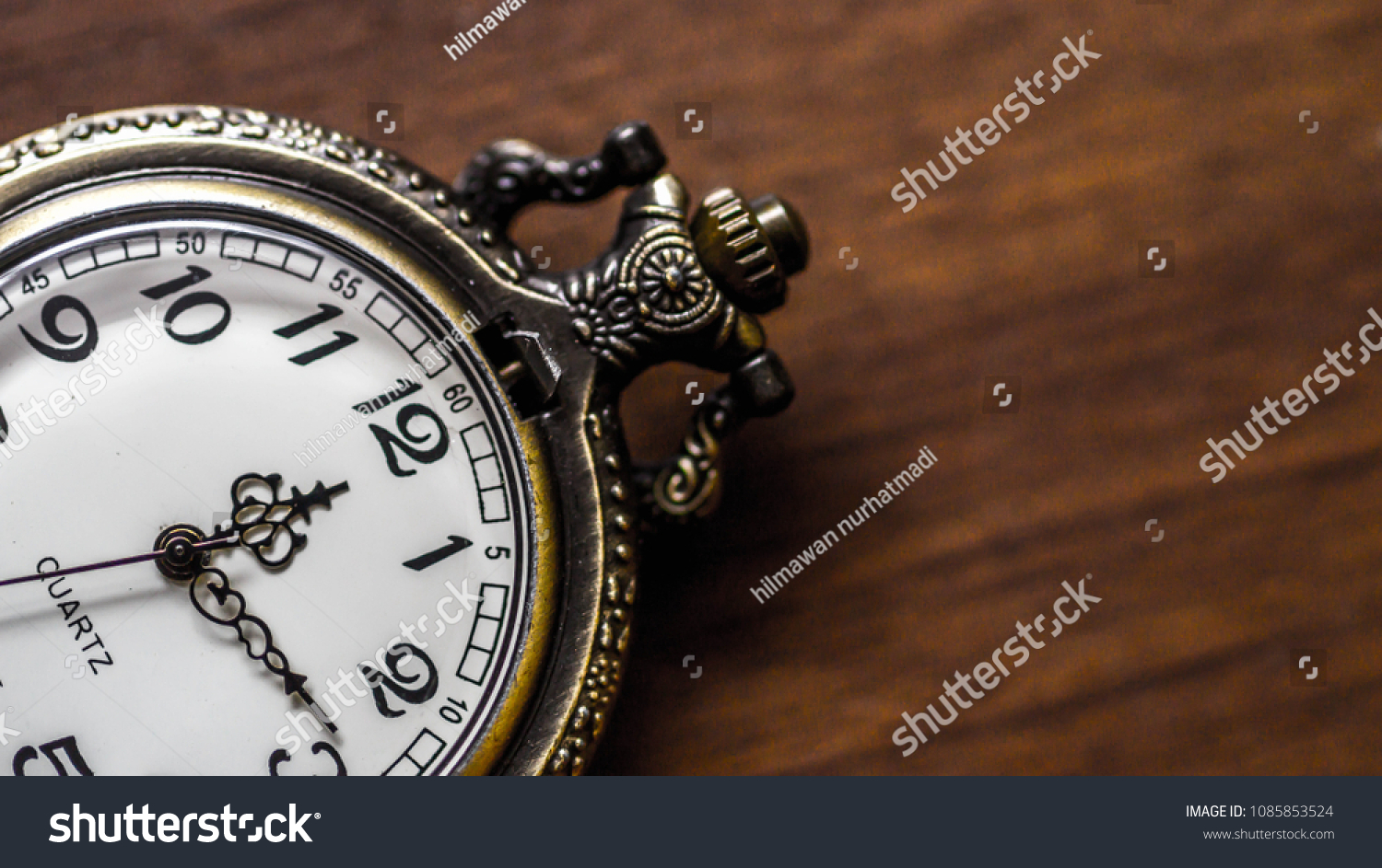 old vintage pocket watch showing time on wooden background #1085853524