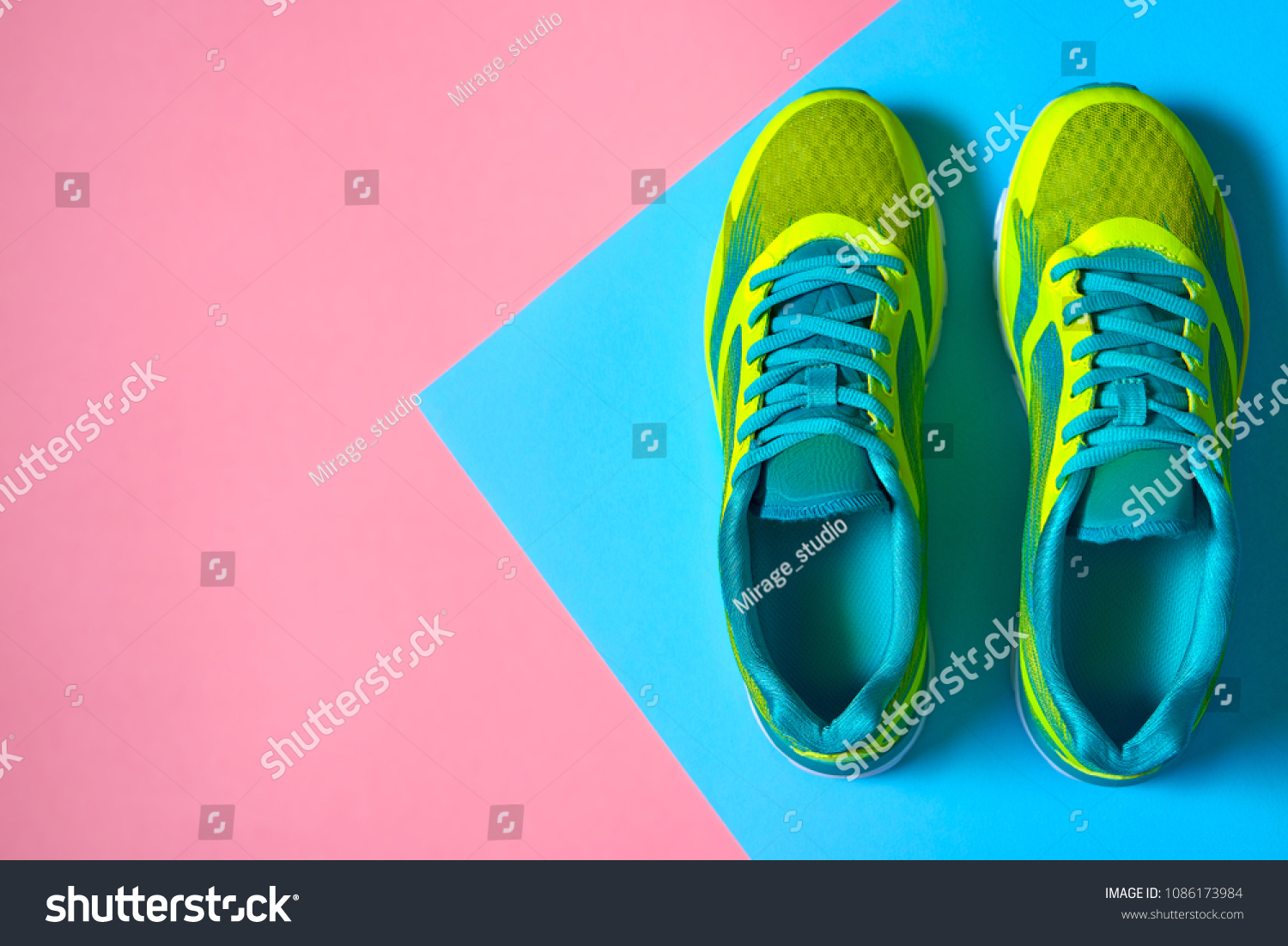 Pair of sport shoes on colorful background. New sneakers on pink and blue pastel background, copy space. Overhead shot of running shoes. Top view, flat lay #1086173984