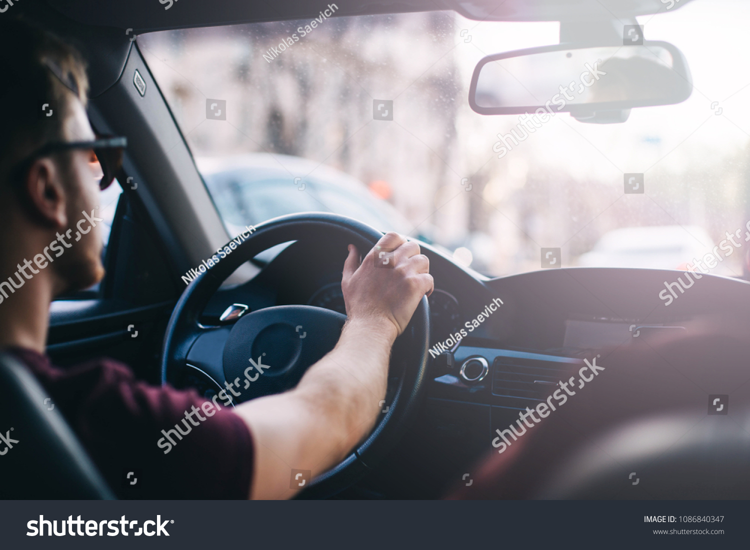 young man driving a business car. trip of a businessman in sunny weather. #1086840347