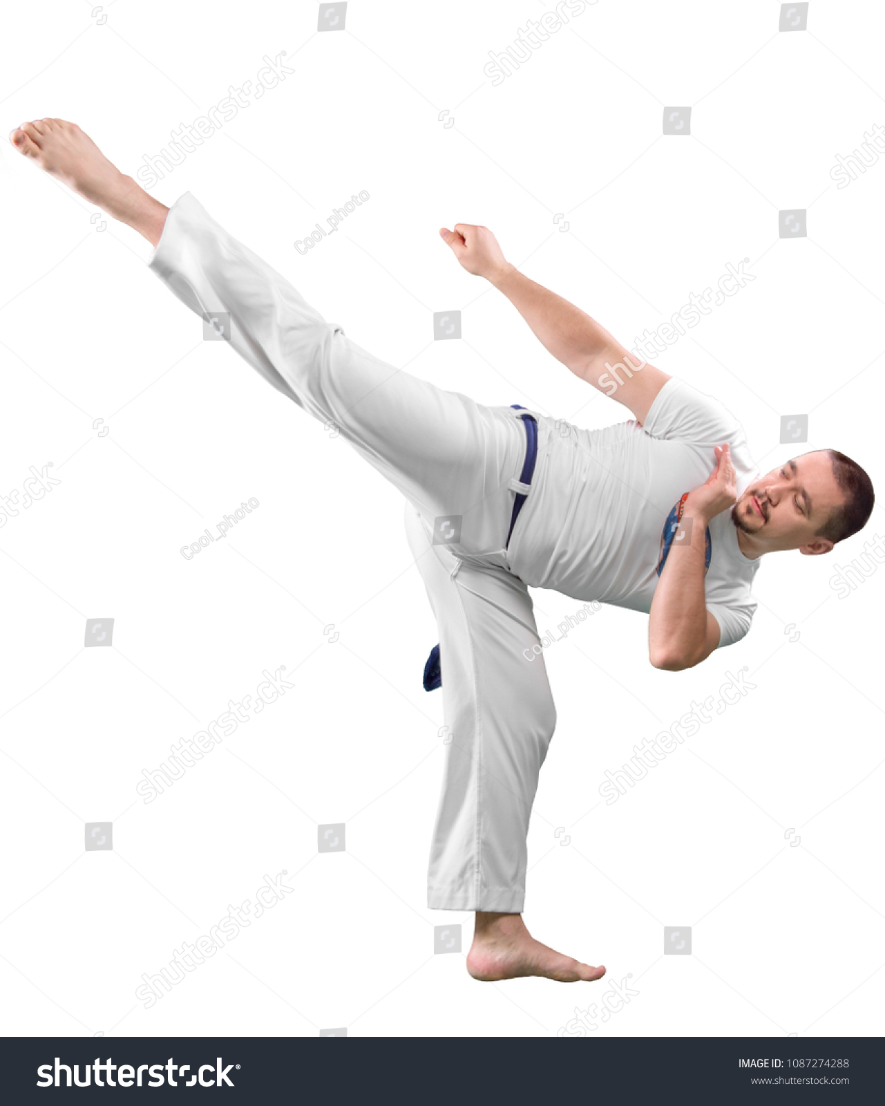 Man trains capoeira in studio isolated on white background. The man does the fighting element of capoeira. #1087274288