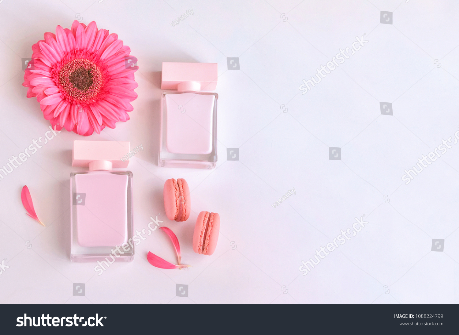 Beautiful perfume bottle with pink flowers and macaroons.  Luxury perfumery background with copy space. Sweet and Floral fragrance concept. #1088224799