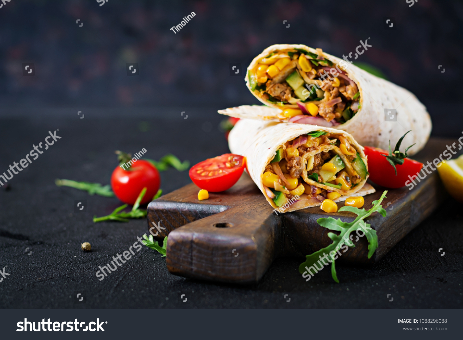 Burritos wraps with beef and vegetables on  black background. Beef burrito, mexican food. #1088296088