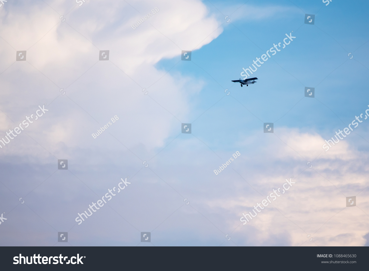 Small plane in the air. Blue sky with white clouds #1088465630