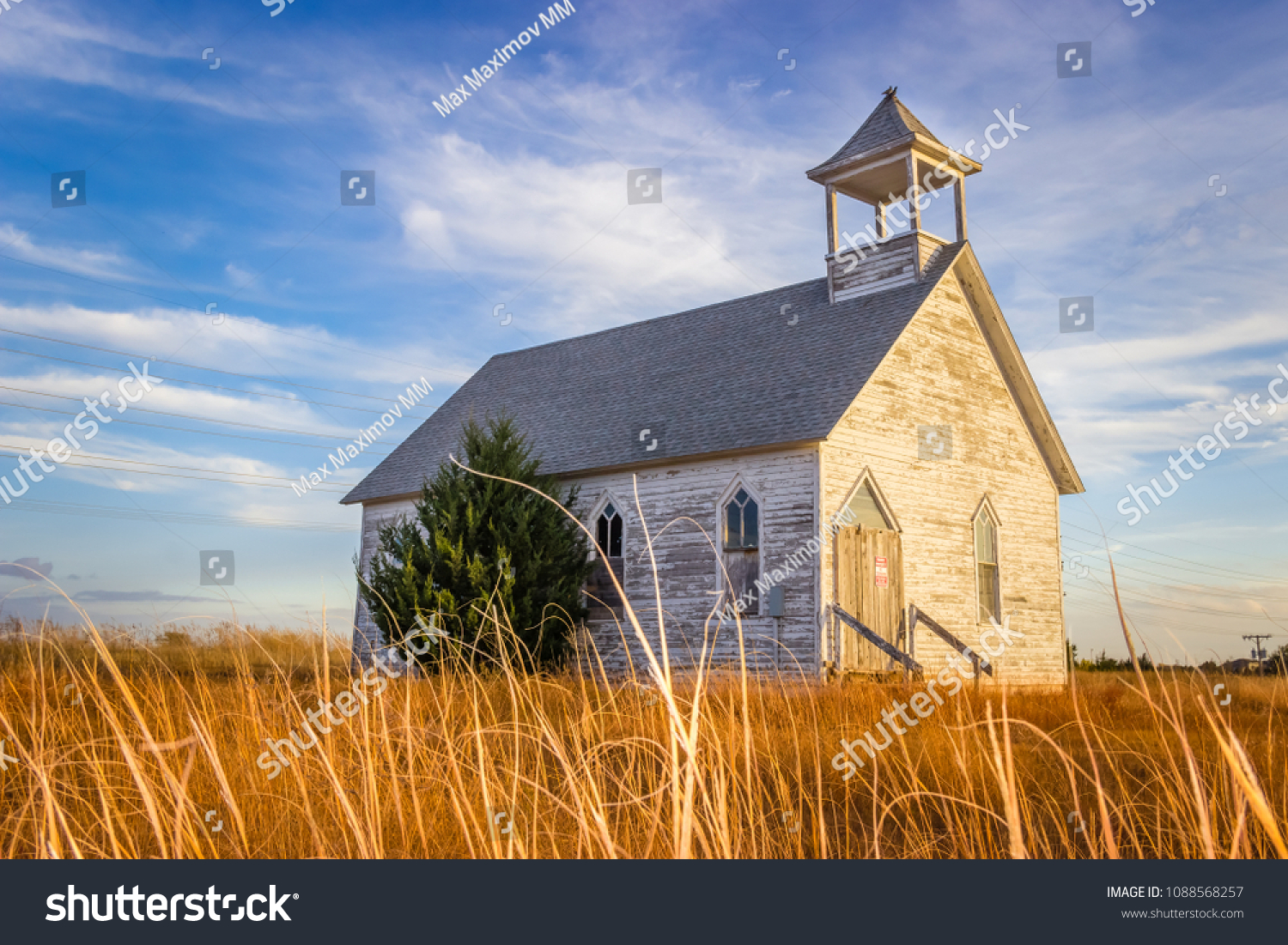 Abandoned Wooden Church Building in the Midwest Prairie under Blue Summer Sky #1088568257