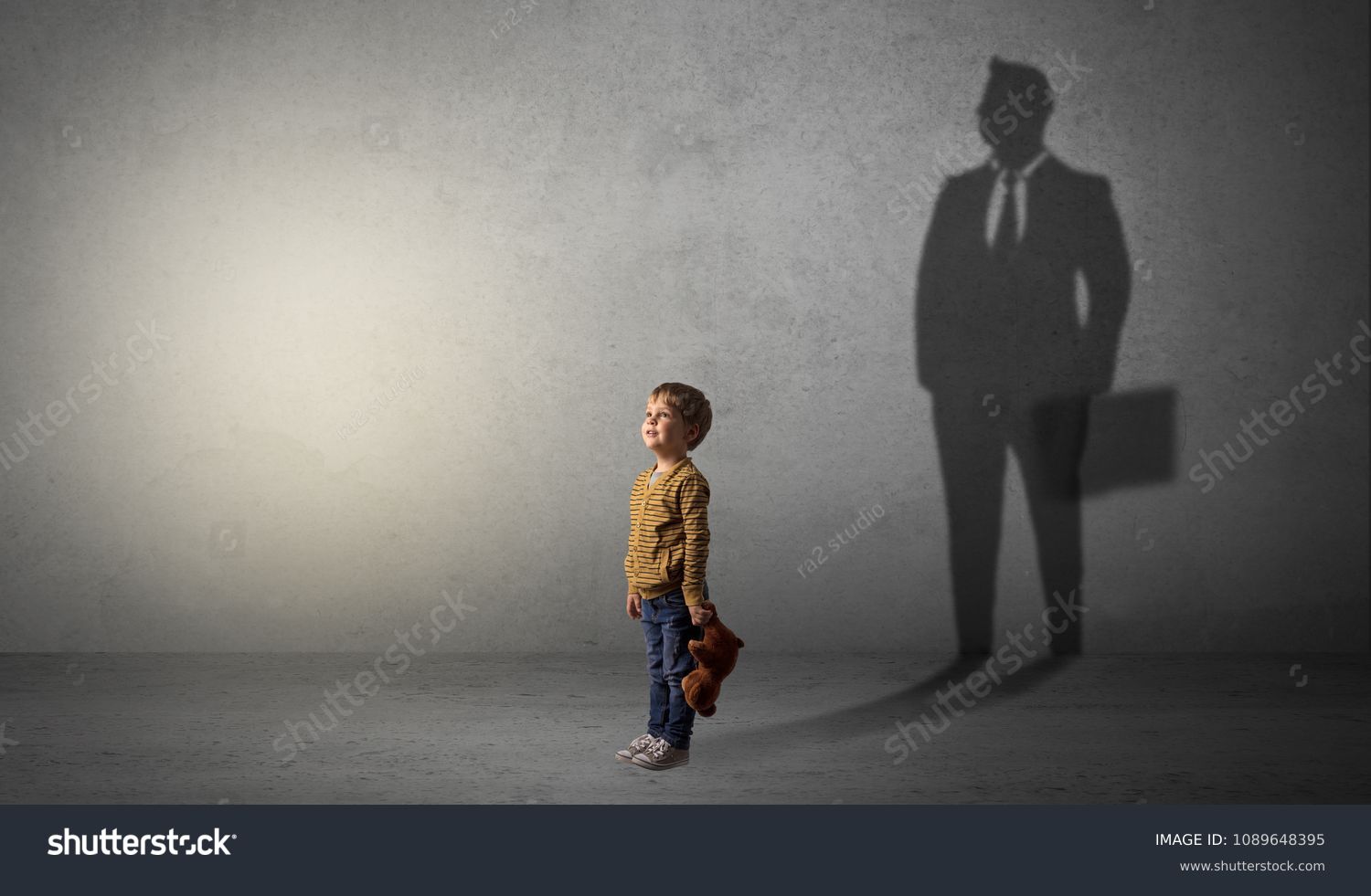 Little boy imagine that he will be businessman and illustrating his future in a big shadow #1089648395