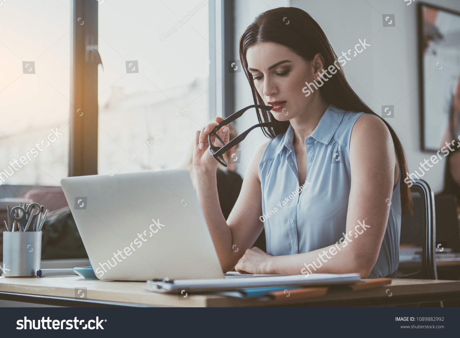 Portrait of pensive businesswoman looking at digital device while sitting at table. Wistful employer at job concept #1089882992