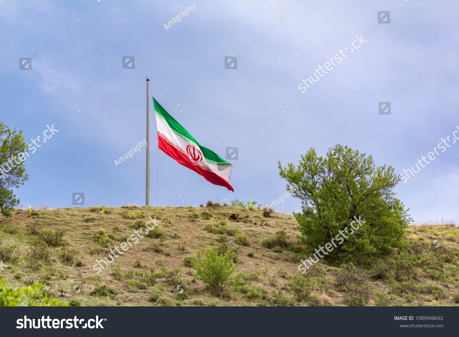 Huge  national flag of Iran on Tehran capital city countryside hillside  #1089948692