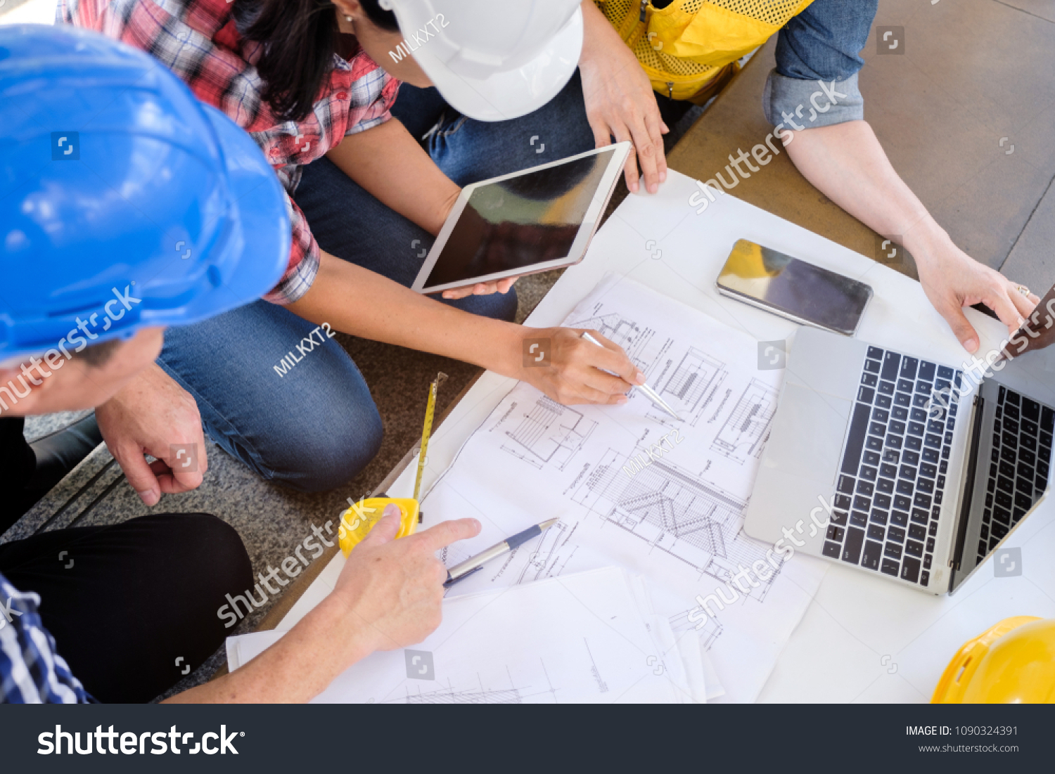 multiethnic diverse team of engineers discussing about new project in city, engineer man and woman work with blueprint in front of building, business people co-working teamwork concept,focus on hand #1090324391