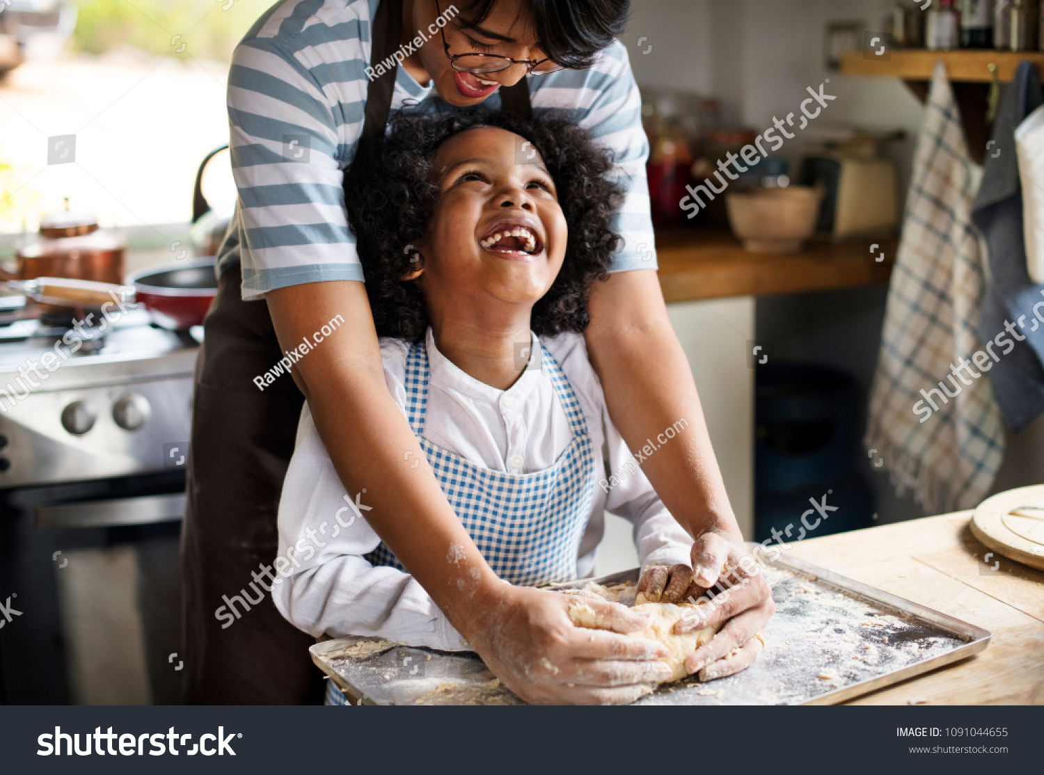 Mother and son kneading dough in the kitchen #1091044655