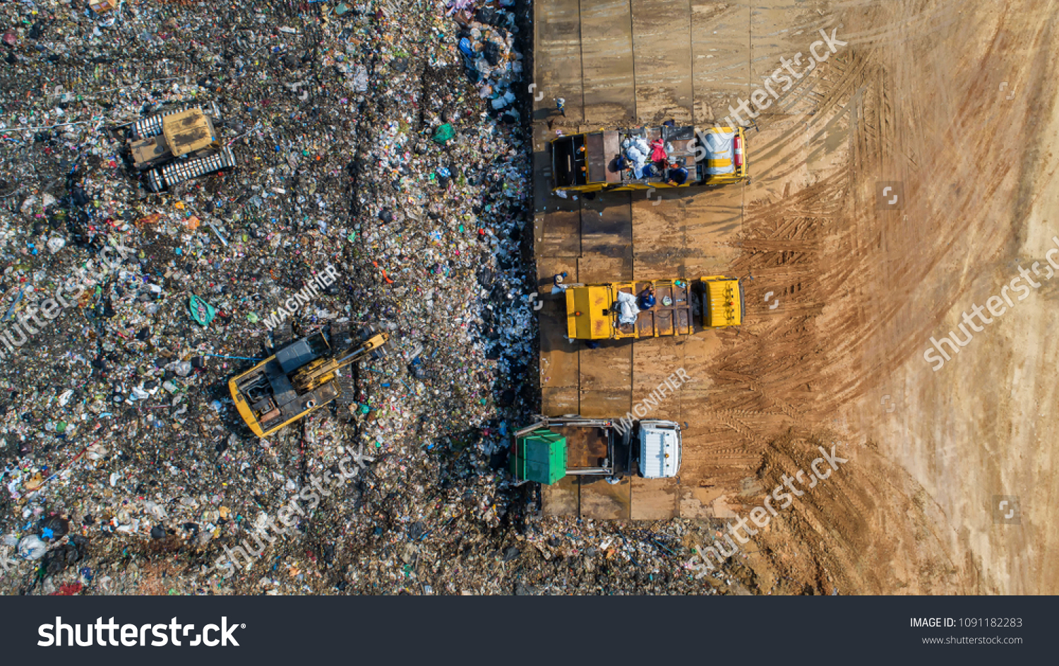 A lot of waste is disposed of in the waste disposal pits. Loaders is working on a mountain garbage. Aerial view and top view. #1091182283