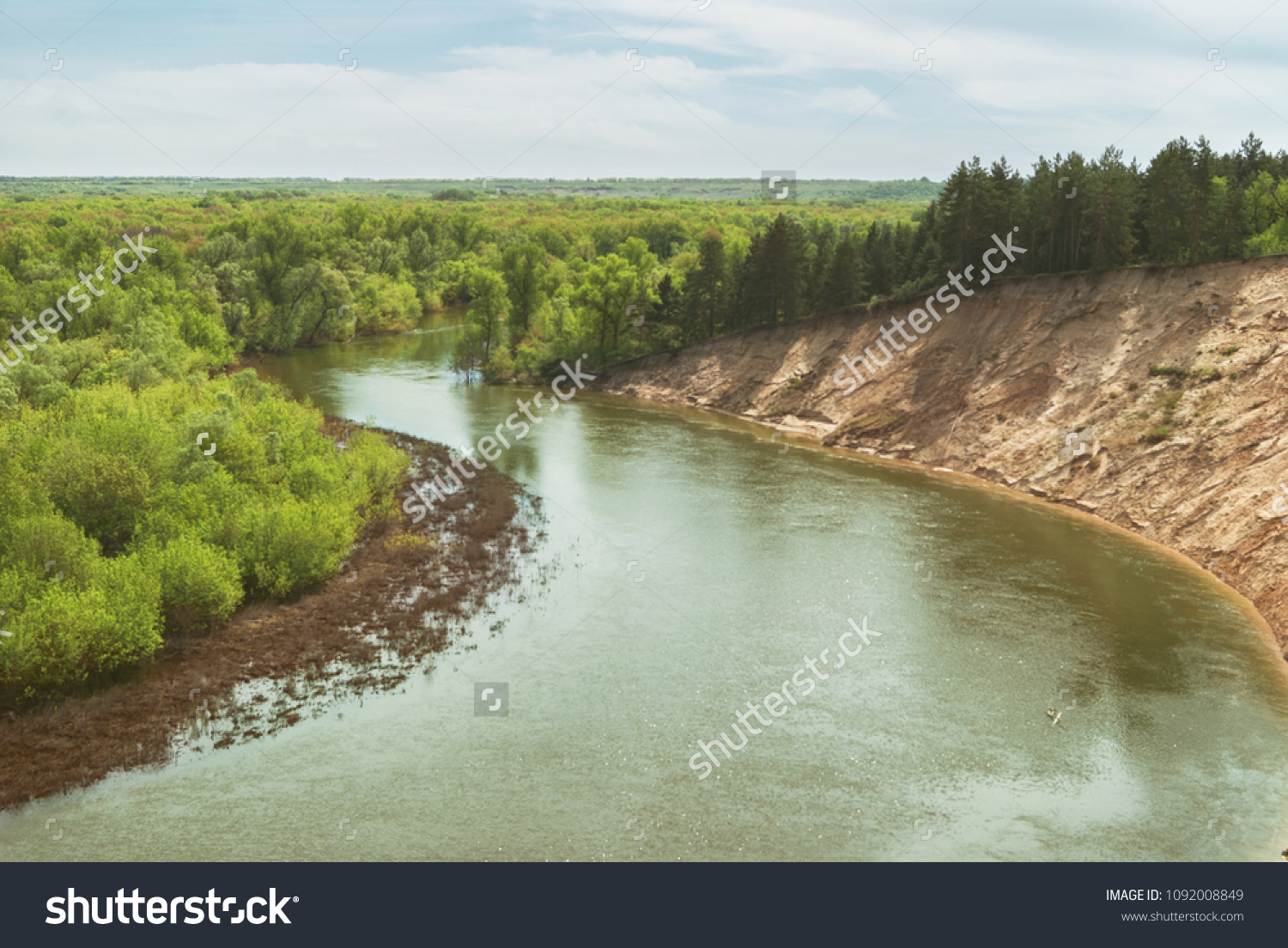 A warm spring day in the forest valley of the Russian river with a steep sandy slope. Landscape #1092008849