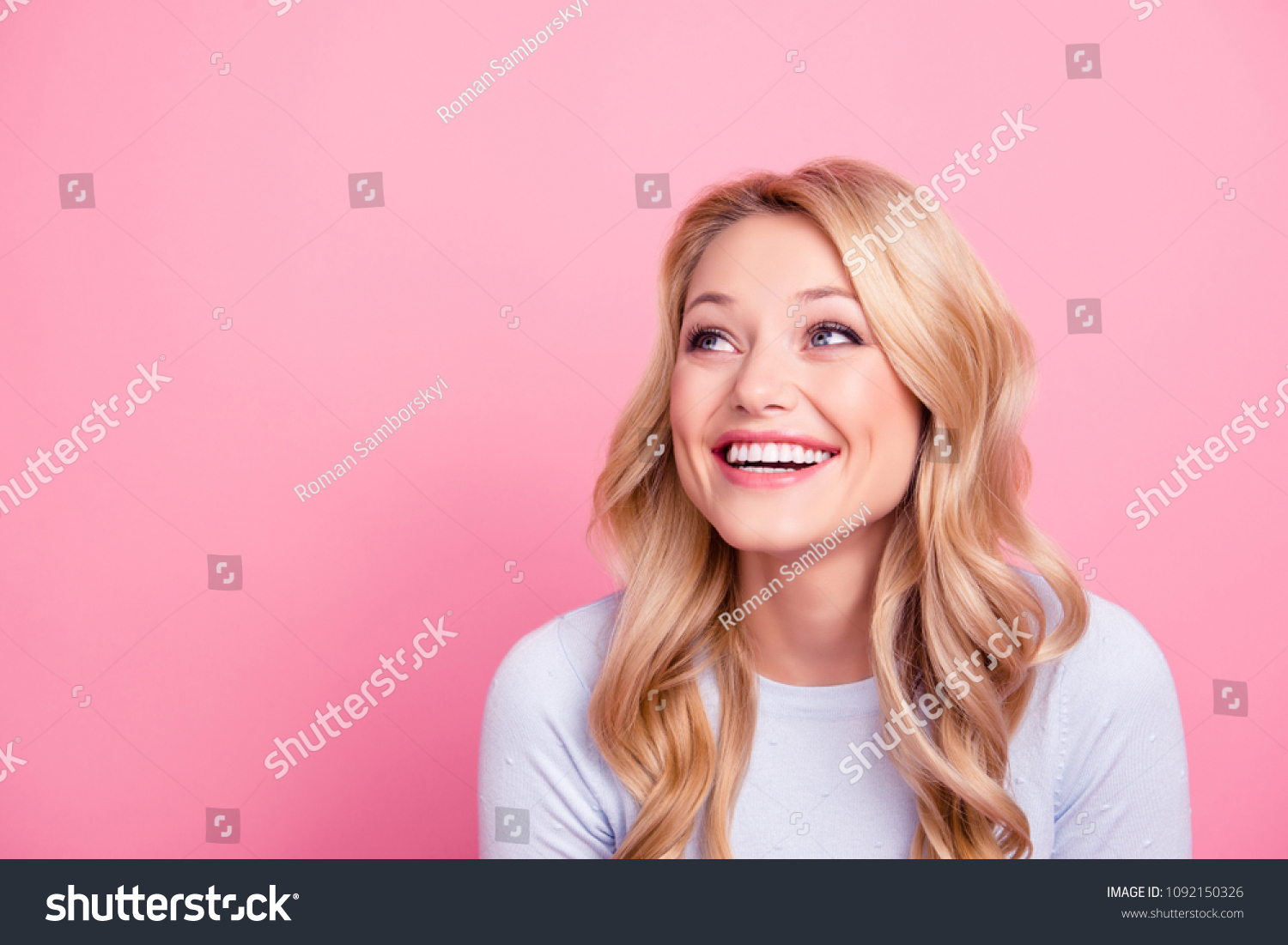 Portrait with empty place of foolish childish funny girl with modern hairdo beaming smile looking at copy space laughing isolated on pink background #1092150326
