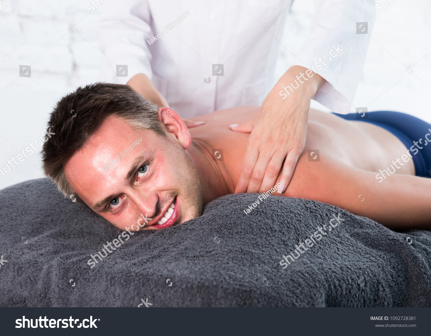 Portrait of young american man enjoying relaxing massage by professional masseuse
  #1092728381