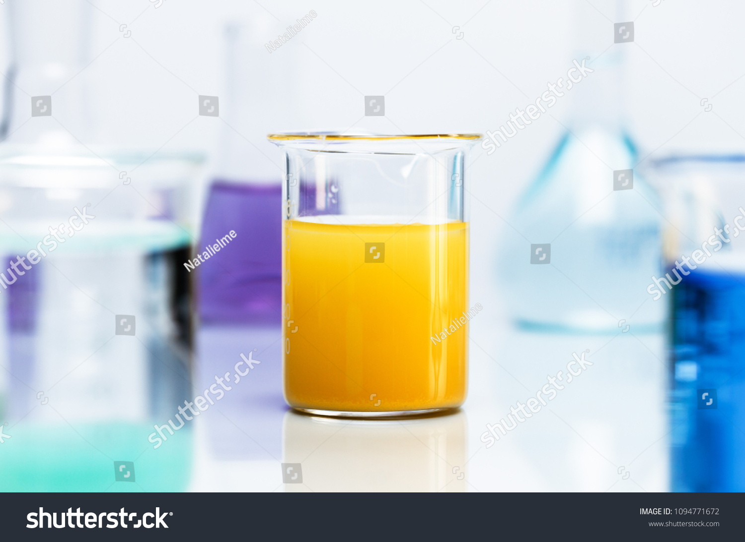 Yellow precipitate in a beaker, surrounded by various chemical lab glassware. #1094771672