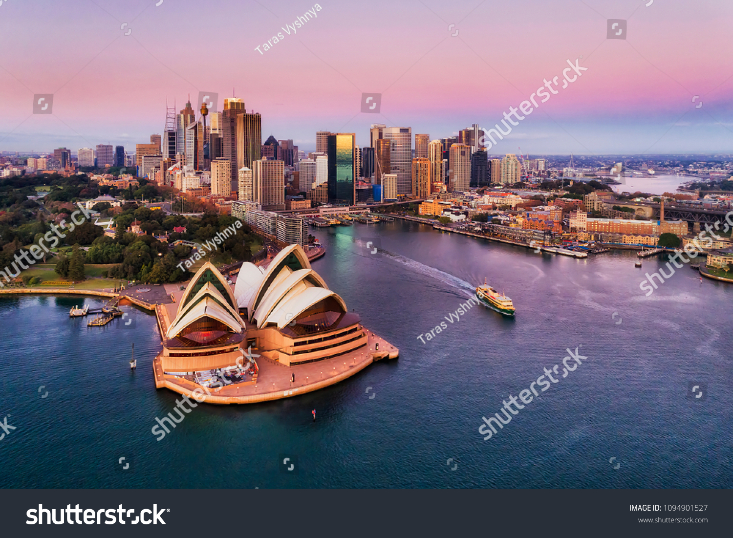 Pinkish colourful sunrise over Sydney city CBD on waterfront of Harbour around Circular quay with major architectural landmarks and symbols of Australia. #1094901527