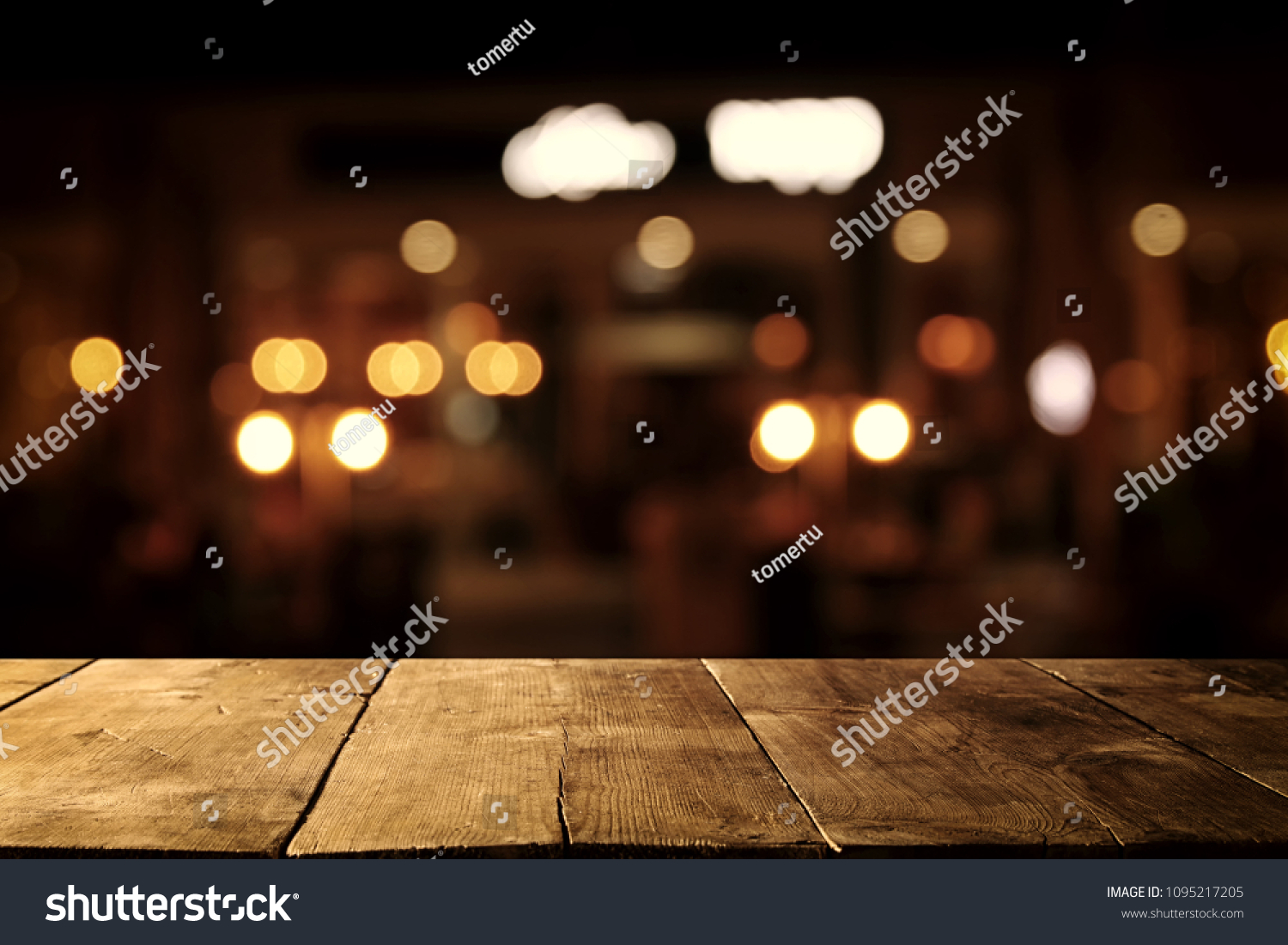 Image of wooden table in front of abstract blurred restaurant lights background #1095217205