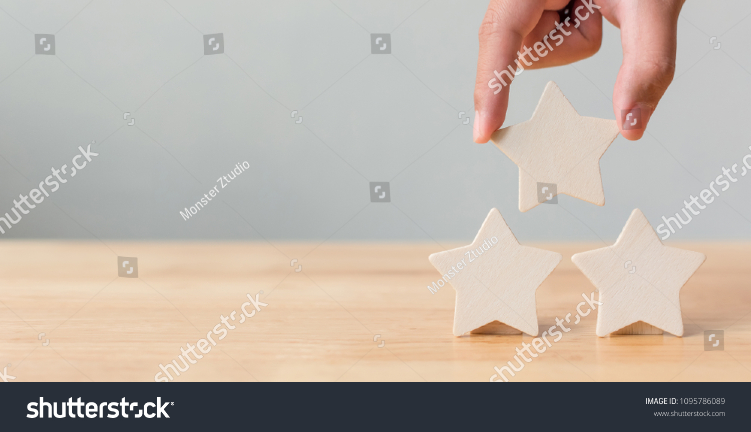 Hand putting wooden five star shape on table. The best excellent business services rating customer experience concept #1095786089