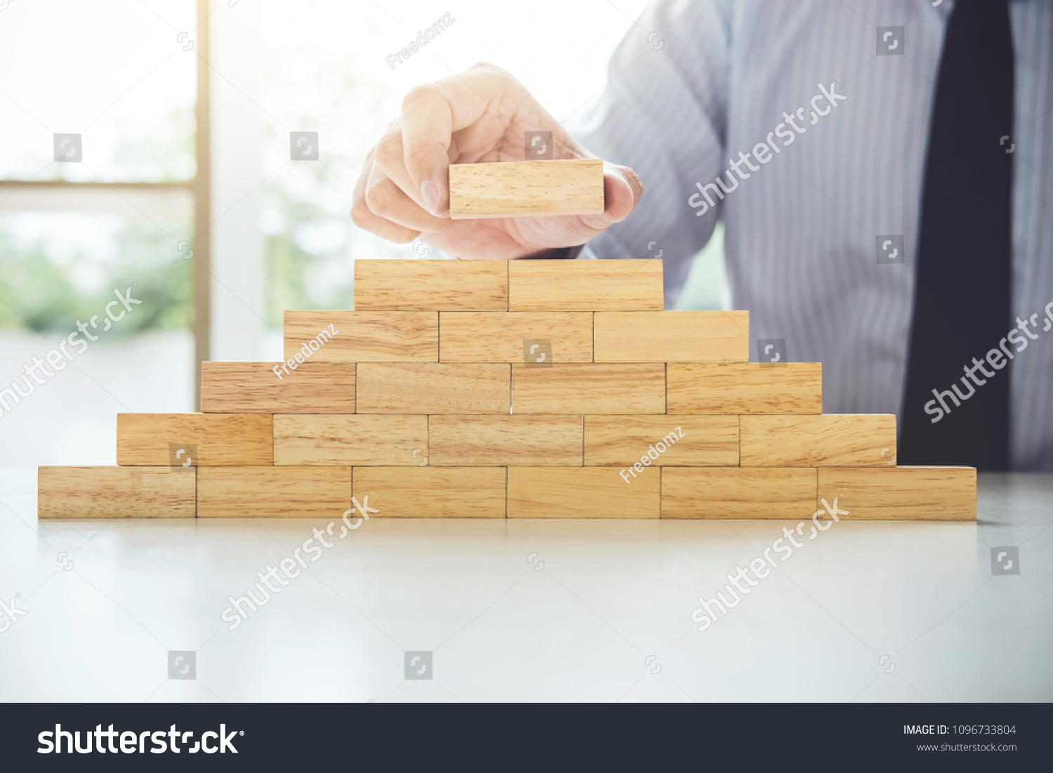 Plan and strategy in business, Risk To Make Business Growth Concept With Wooden Blocks, hand of man has piling up and stacking a wooden block. #1096733804
