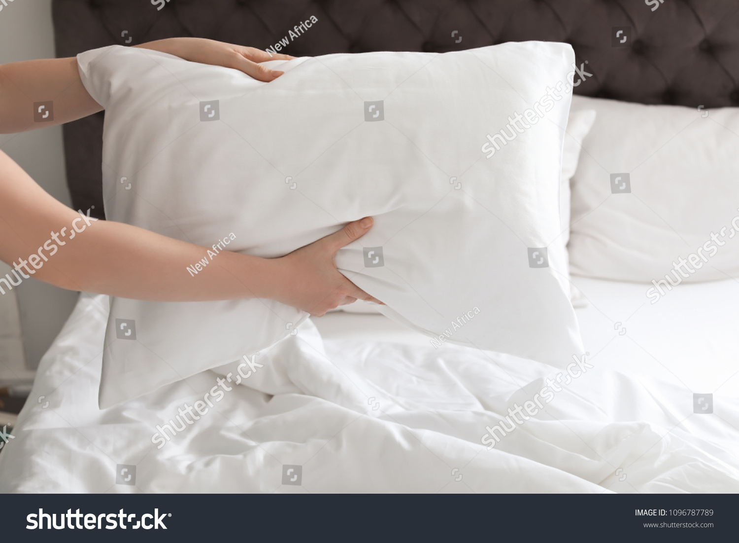 Young woman holding white pillow over bed, closeup #1096787789