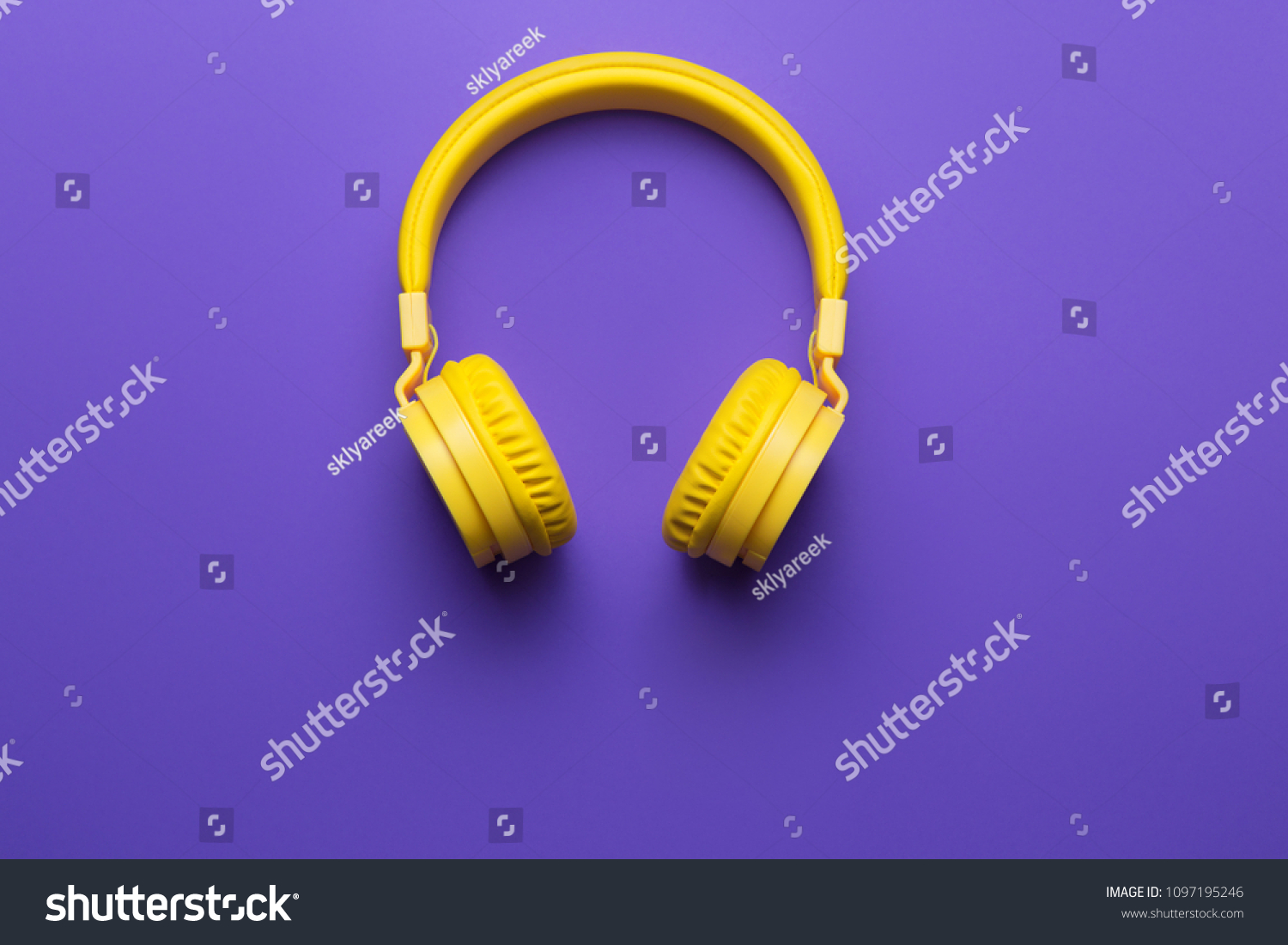 Yellow headphones on purple background. Music concept. #1097195246