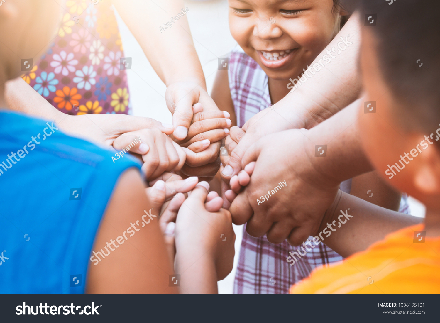 Children and parent holding hands and playing together with unity and teamwork #1098195101