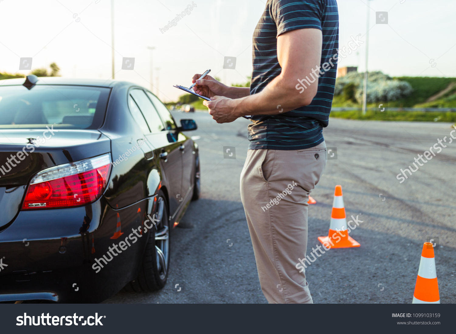 Driving school or test. Driving instructor writing notes after parking lesson. #1099103159