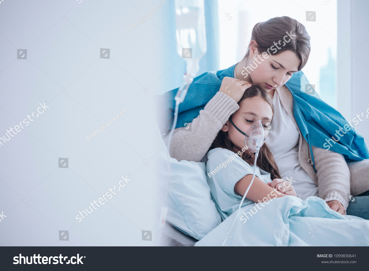 Worried mother taking care of her daughter wearing an oxygen mask in the hospital #1099830641