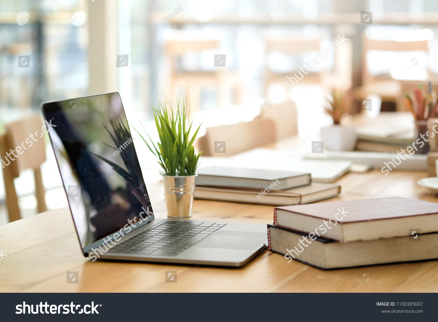 Desk with laptop, books and business office background. #1100305607