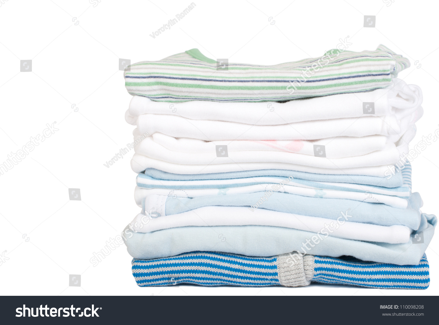 a stack of baby clothes on a white background with copy space #110098208