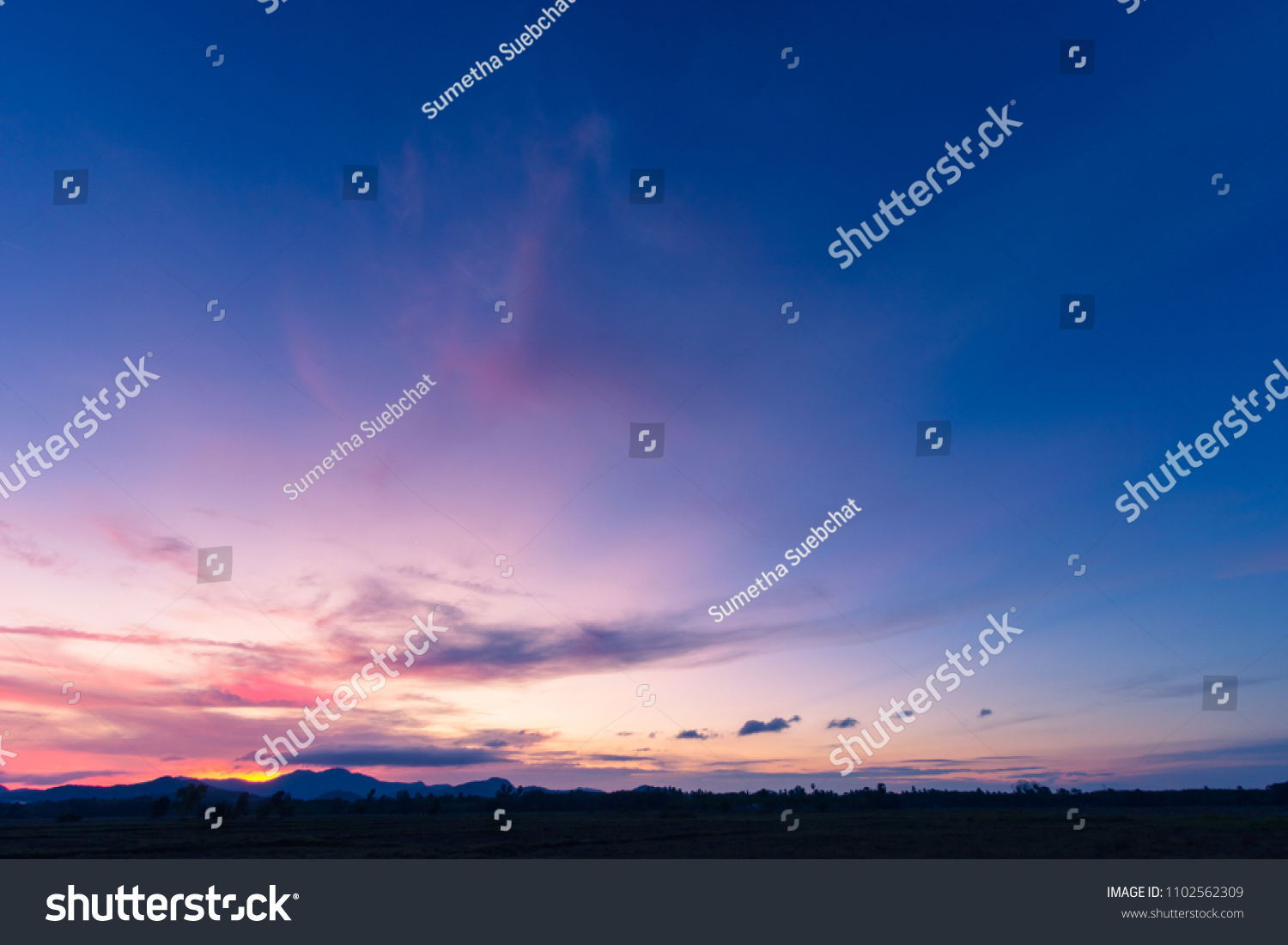 Evening sky,Amazing Colorful sky and Dramatic Sunset,Majestic Sunlight Cloud fluffy,Idyllic Nature Peaceful Background, Summer Dark Blue Hour on Dusk,Purple Nightfall Silhouette mountain on twilight #1102562309