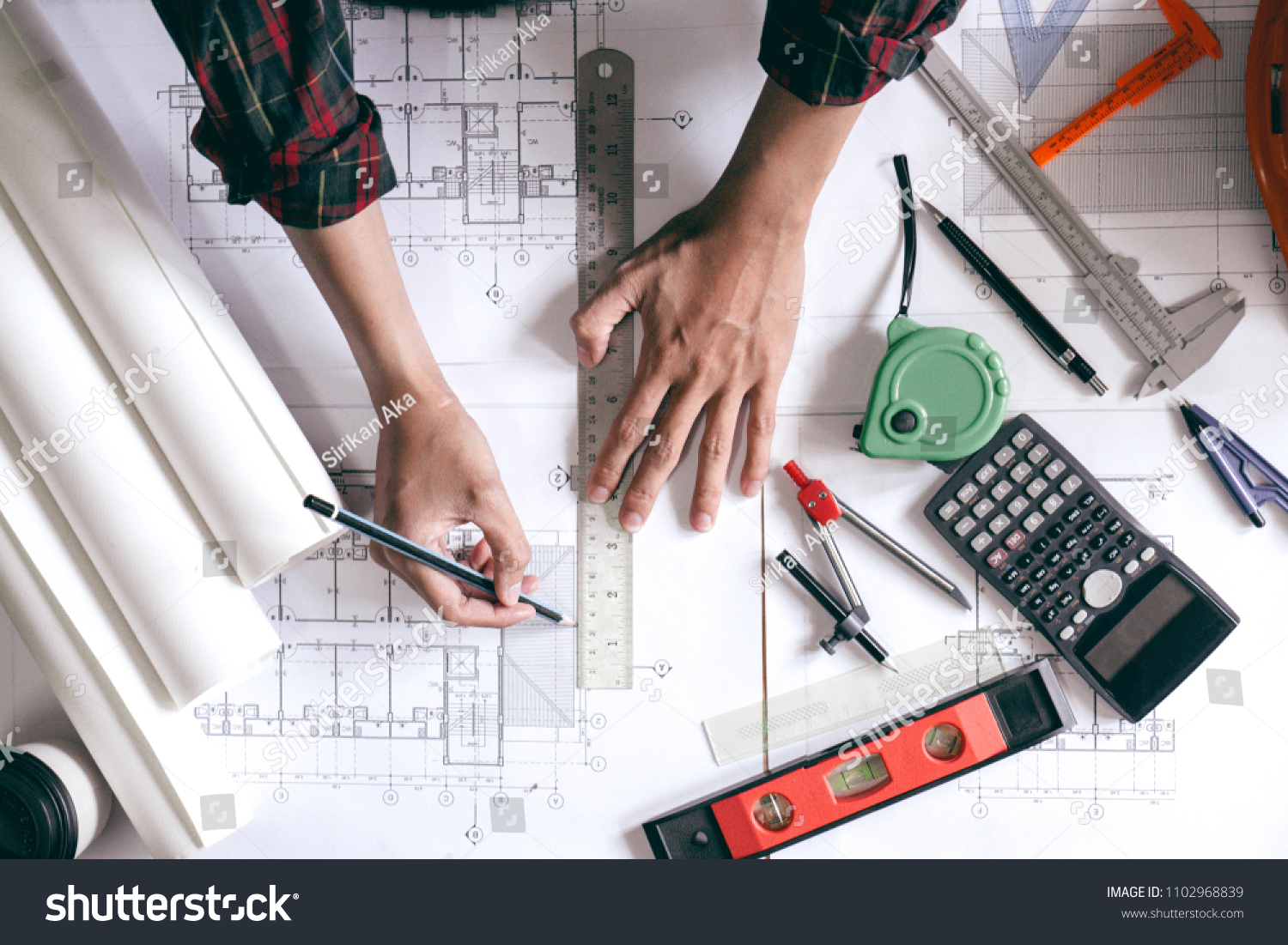 Architect is designing blueprints for home construction. #1102968839