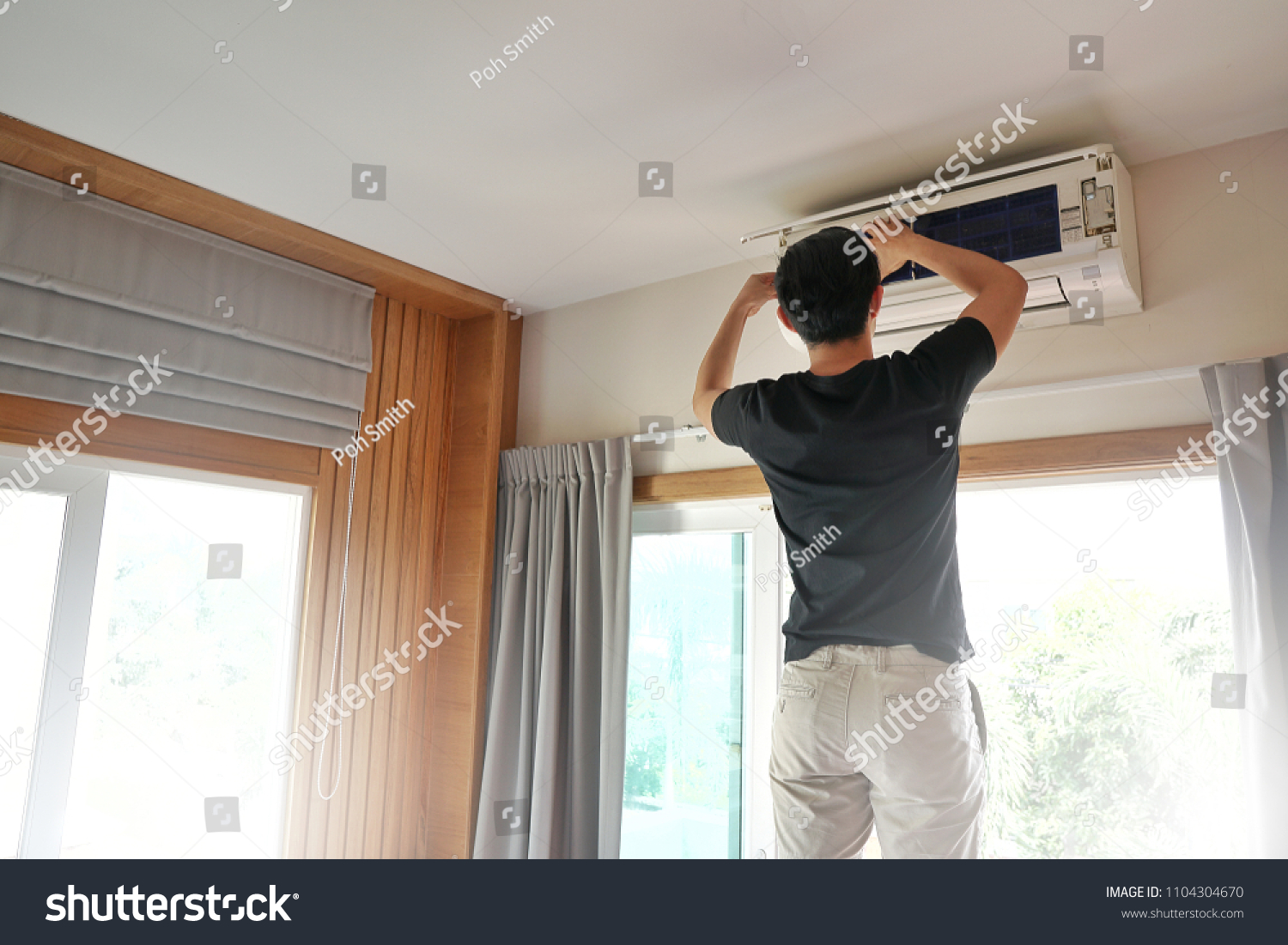 Technician man repairing ,cleaning and maintenance Air conditioner on the wall in bedroom.On site home service,Business ,Industrial concept. #1104304670