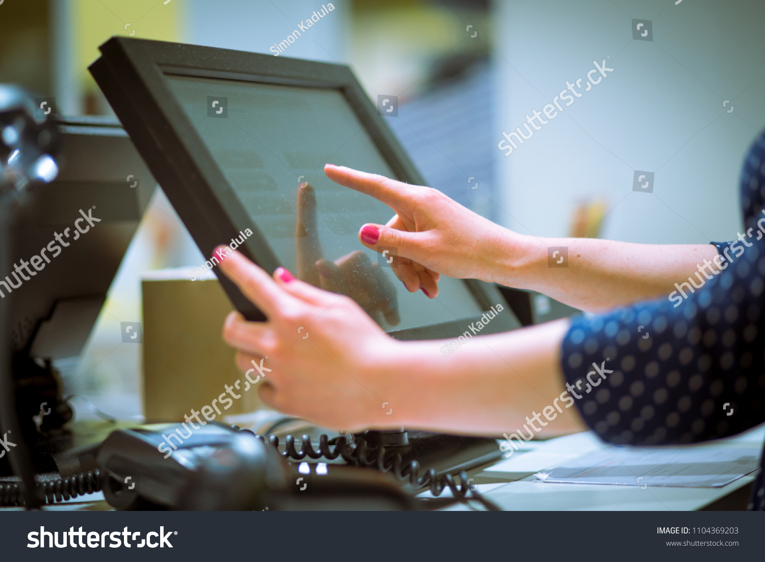 Saleswoman doing process payment on touchscreen pos, counting sale #1104369203