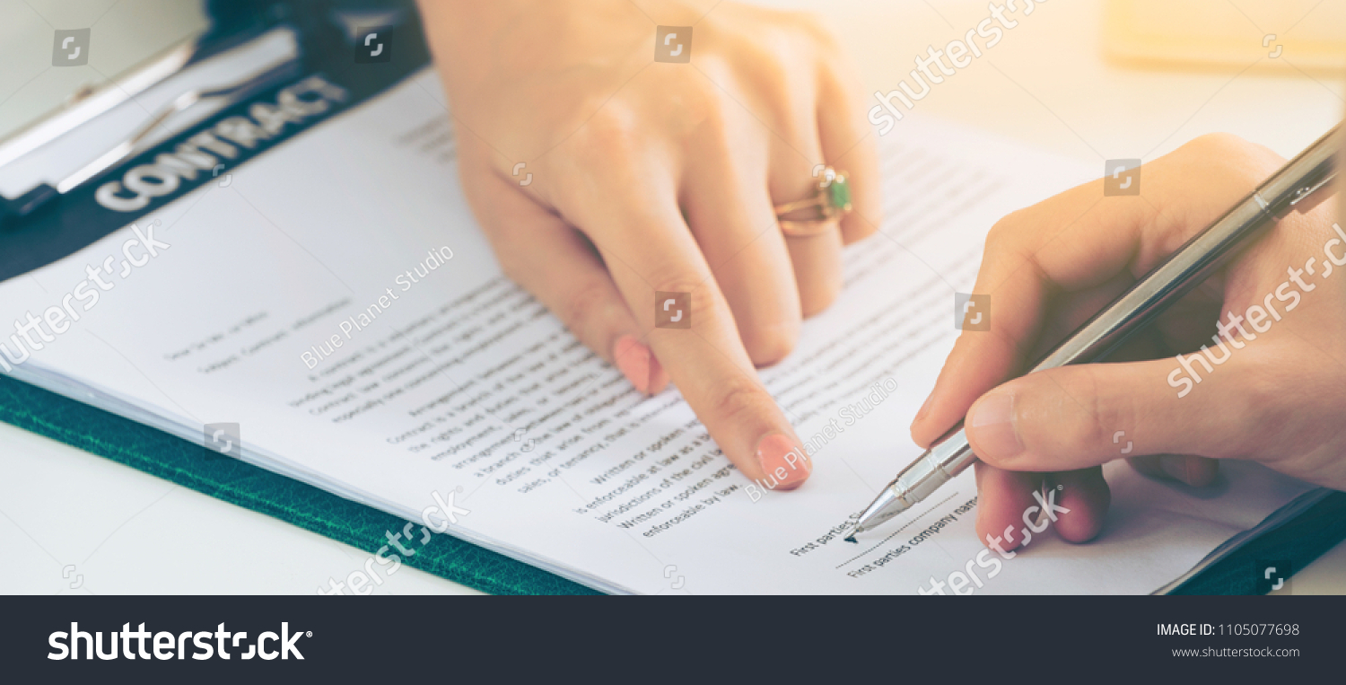 Businesswoman signs agreement contract with another businesswoman at the office. Concept of business partnership and legal agreement of lawyer. #1105077698