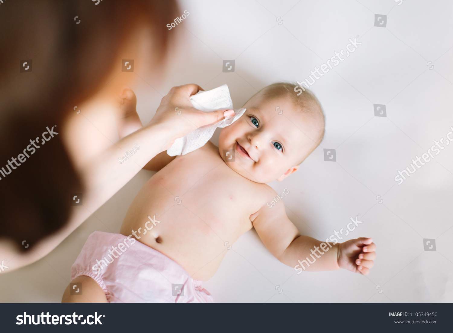 Mother Wiping Baby's Face #1105349450