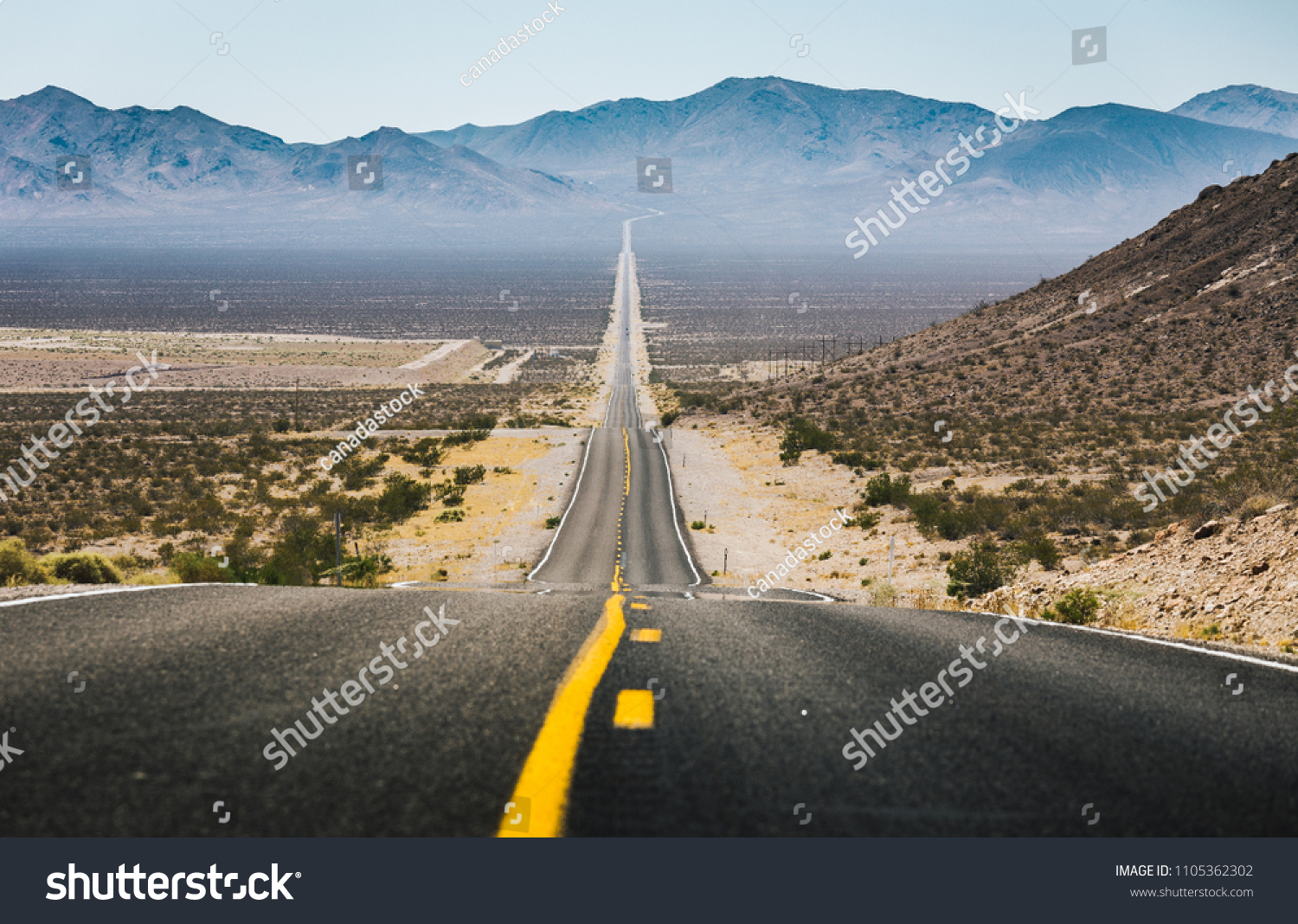 Classic panorama view of an empty long highway road in the American West on a beautiful sunny day in summer, USA, North America #1105362302