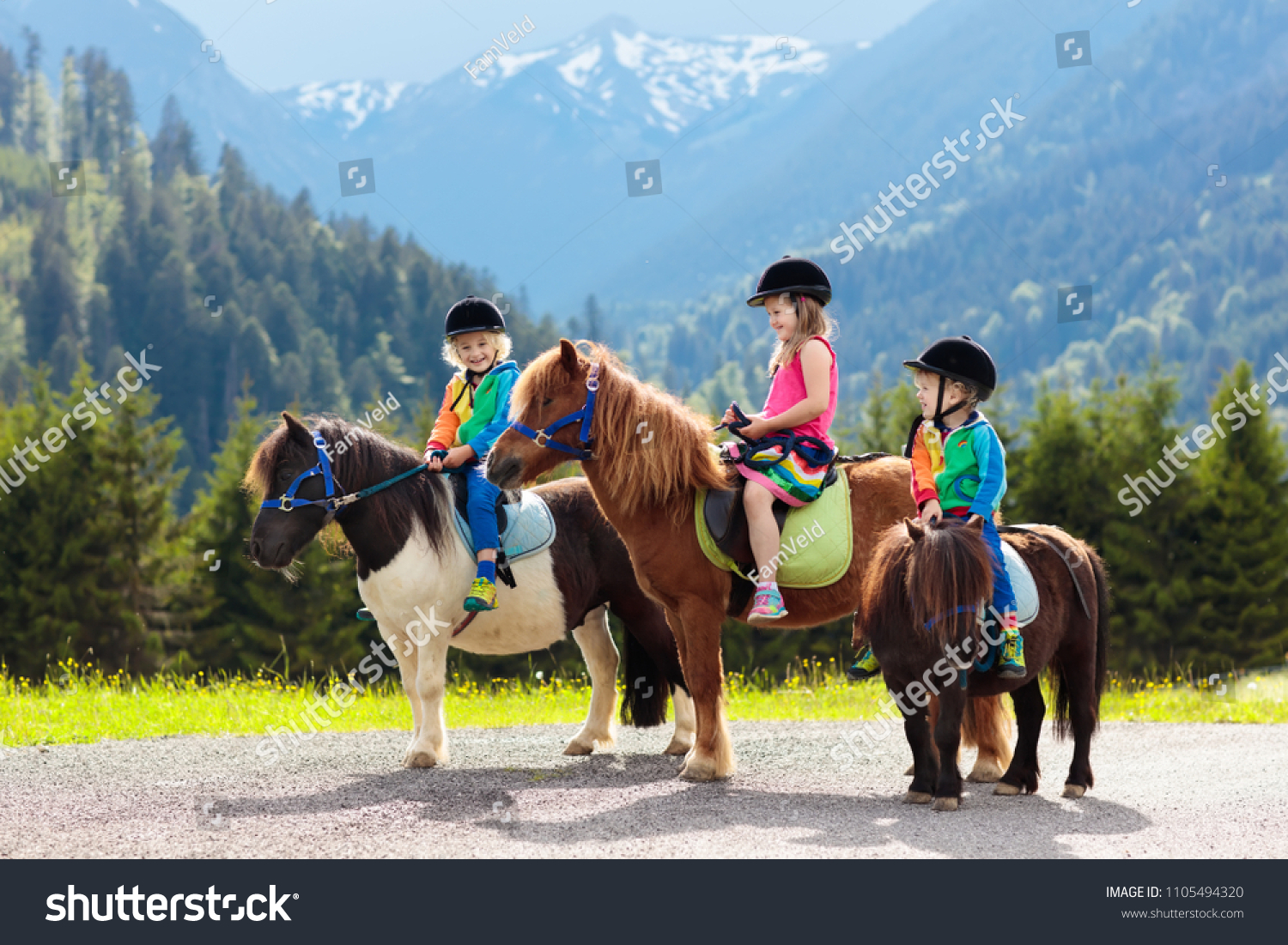 Kids riding pony in the Alps mountains. Family spring vacation on horse ranch in Austria, Tirol. Children ride horses. Kid taking care of animal. Child and pet. Little girl and boy in saddle on pony. #1105494320